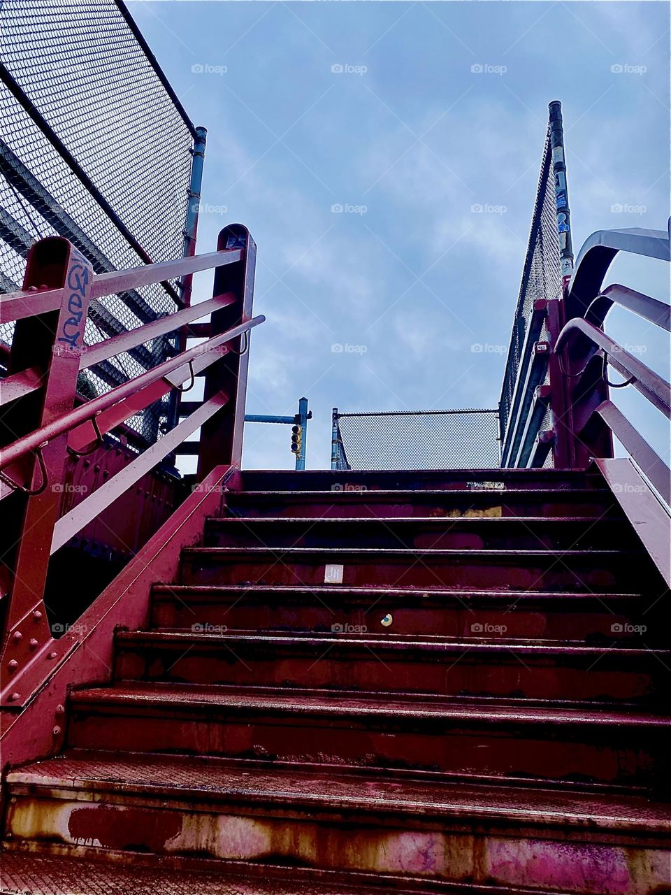 This red metal staircase in the style of industrial minimalism can be found leading up to the pedestrian lane of the “Pulaski Bridge” at “Newtown Creek” in LIC, Queens, NY. 2023. Hypnotic Productions