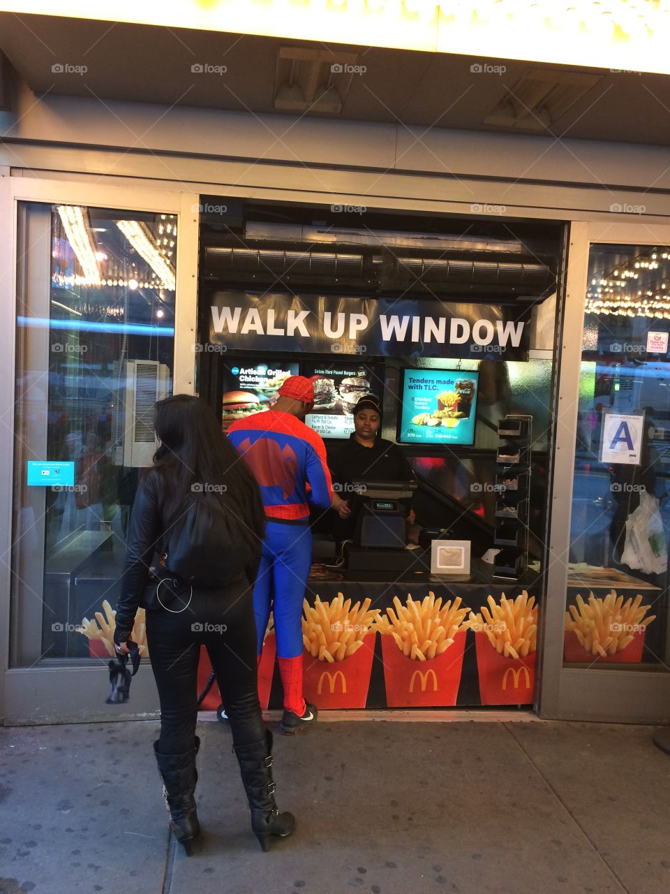 Spider-Man buying some fries. Spider-Man waiting on a McDonald's line in NYC