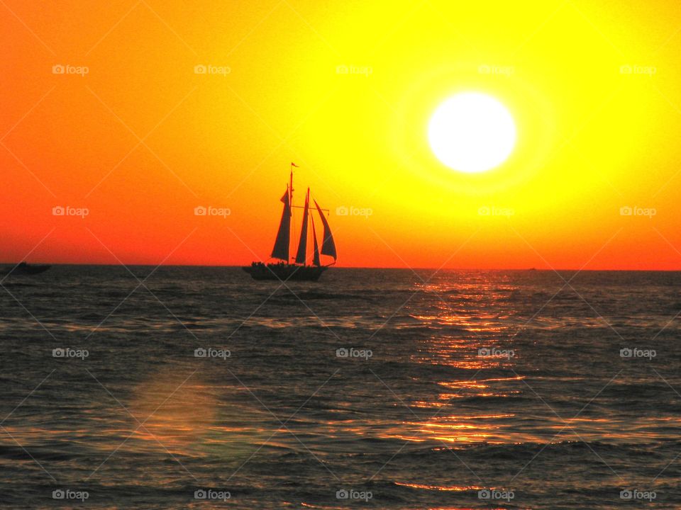 sailboat in the water at sunset