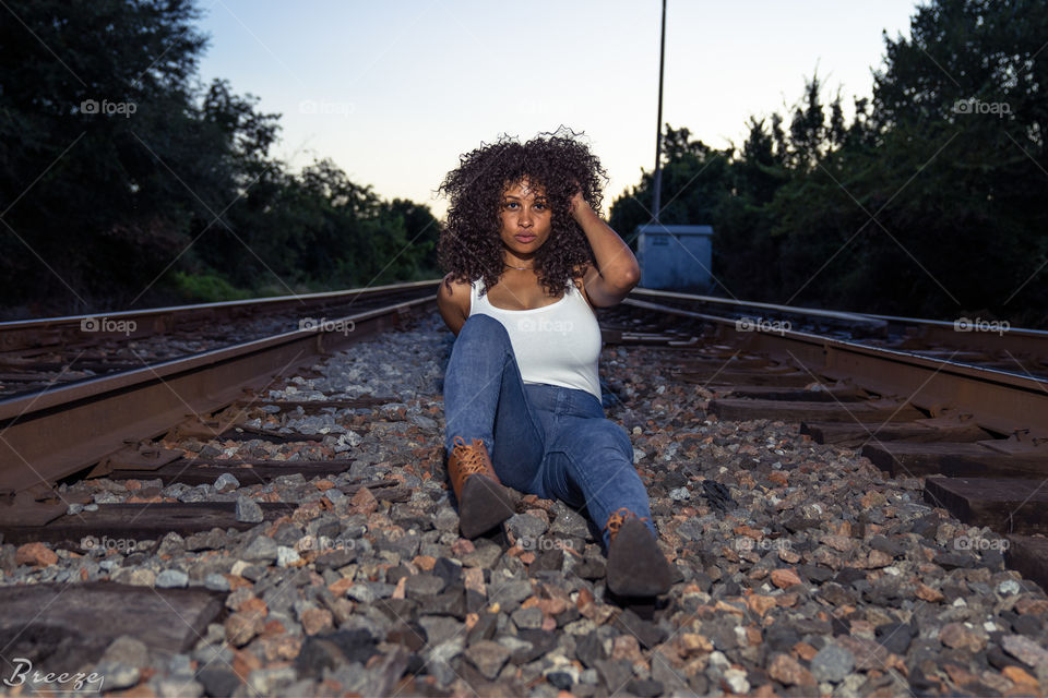 Woman sitting on railway track