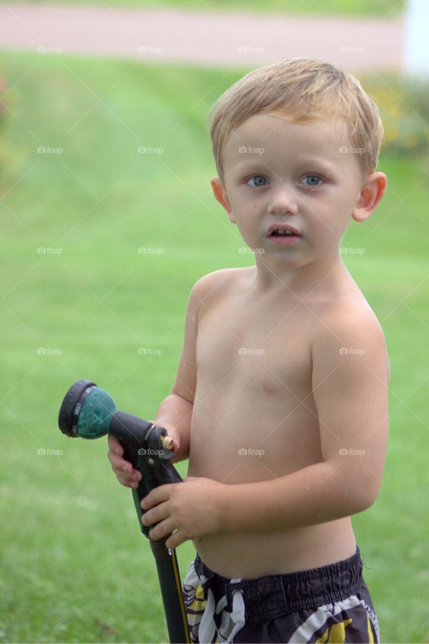 Portrait of a boy holding hose
