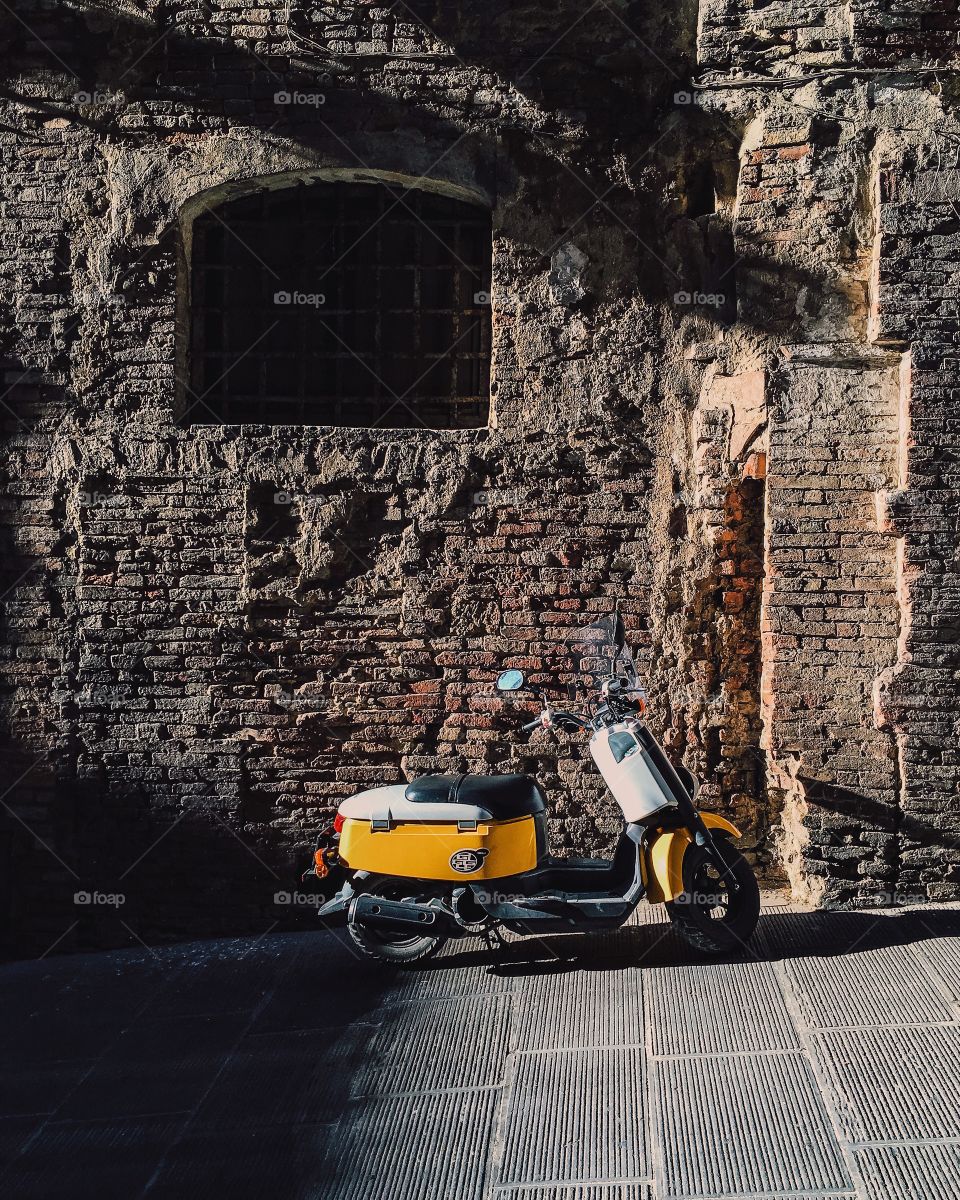 Yellow scooter in the city of Siena