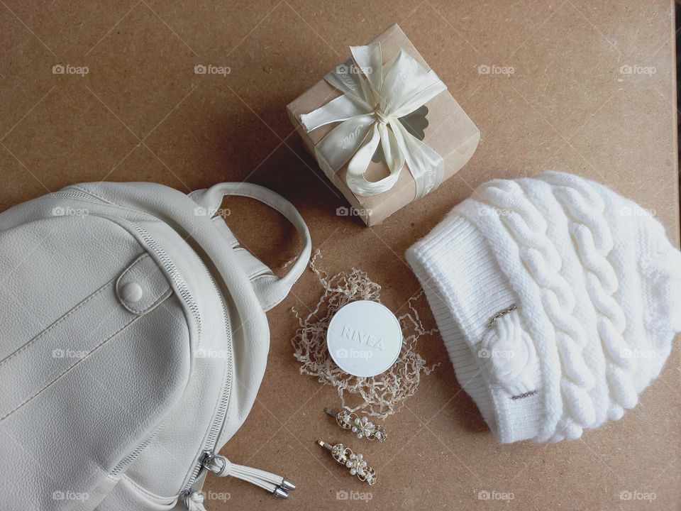 white bag, warm white hat and nivea day cream.