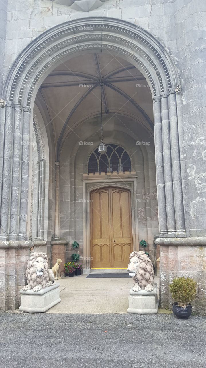 Killymoon Castle entrance, lion statues flanking the door, beautiful arches and architecture