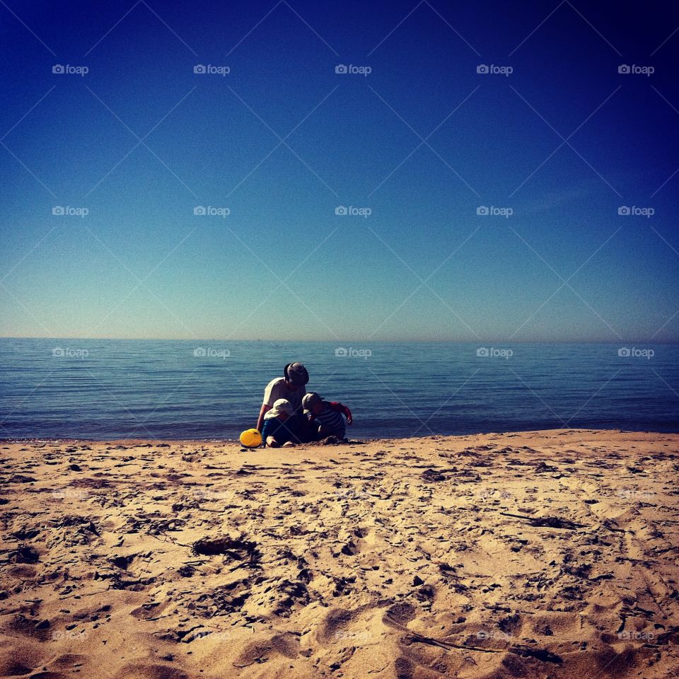 Father and sons playing at the beach