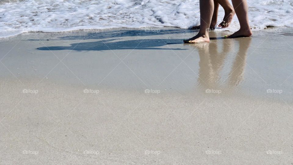 Shadows of a couple walking on the beach 