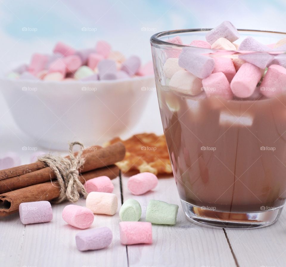 A glass of hot chocolate with colorful marshmallows