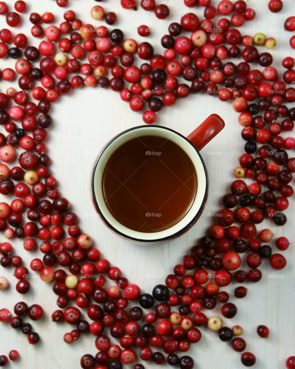 cup of tea and cranberries in heart shape