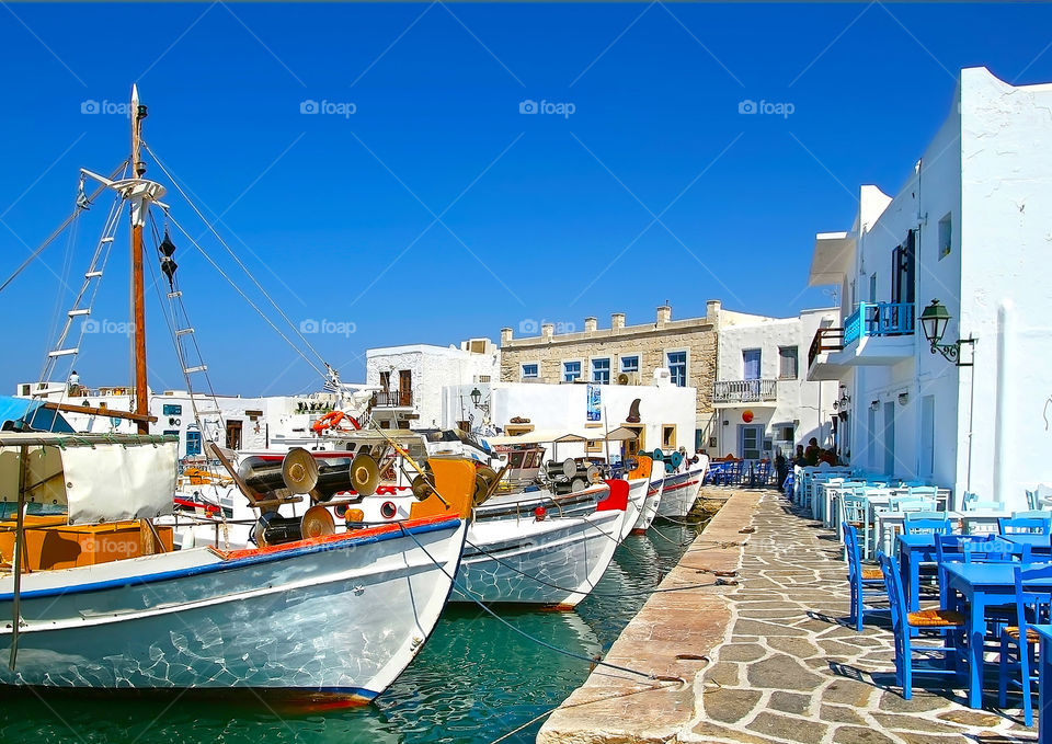 European marina under perfectly blue skies, boats and cobble stone walkway