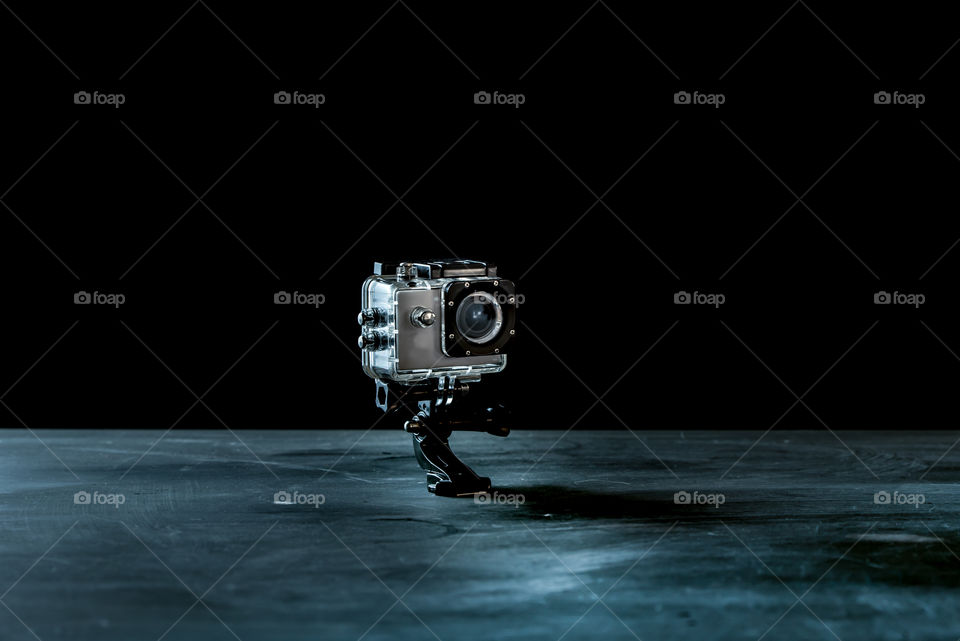 small action camera isolated on dark background as a symbol of photographic work