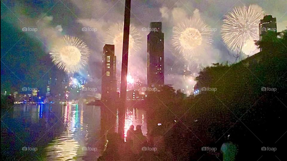 Now & then a powerful combined light beam sweeps over the onlookers and the area they occupy on the particularly large dock at the end of the LIC, Queens side of „Newtown Creek“, an ocean inlet of NYC‘s „East River“. 2022. Hypnotic Productions