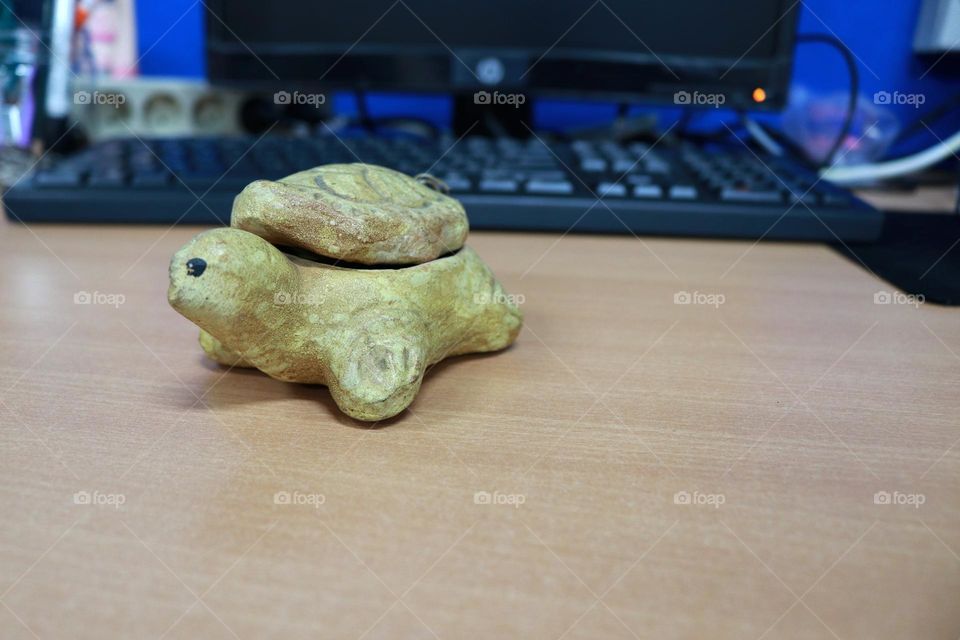 Photo of a turtle statue made of stone, this statue is on the table
