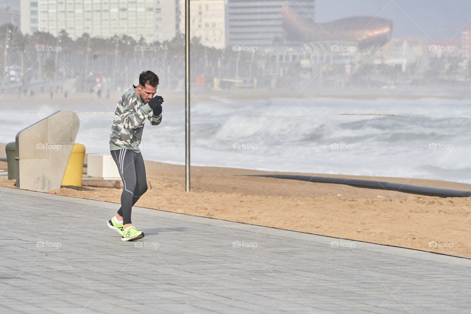 Practicing Boxing by the sea in a cold and grey day