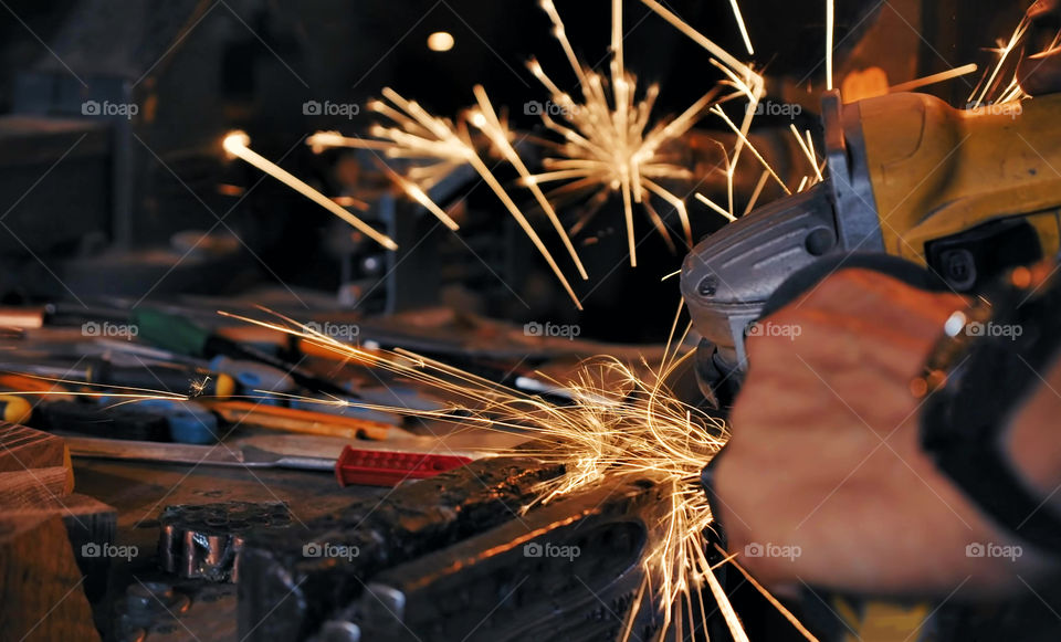 sparks made by using electric disc grinder polishing the surface metal