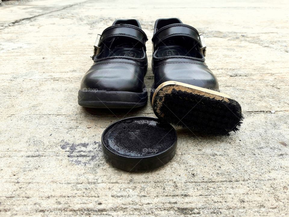 Shoes with shoe polish on cement floor