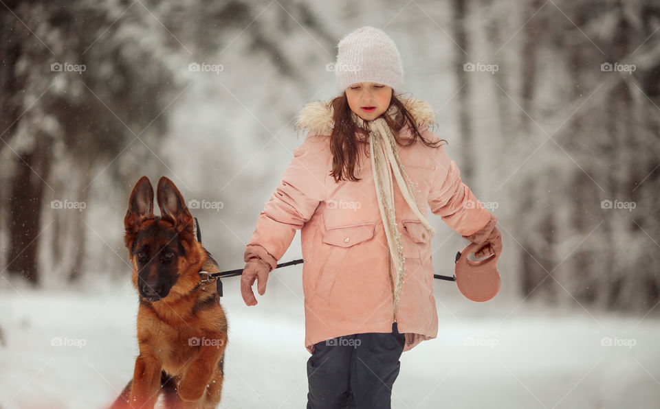 Portrait of beautiful Little girl and puppy at winter forest