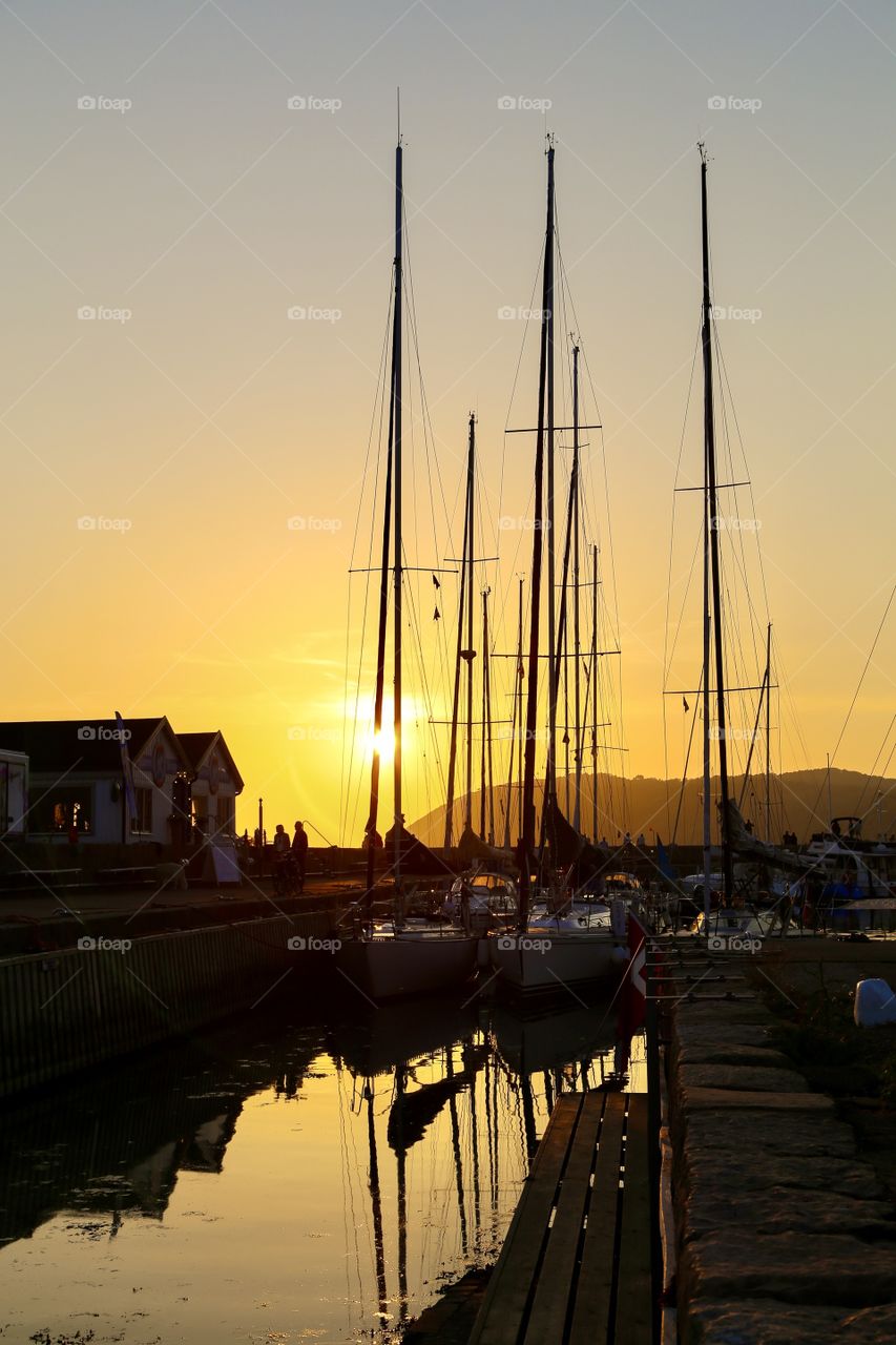 Sunset in the harbor of Mölle in Sweden and Kullaberg showing up behind 