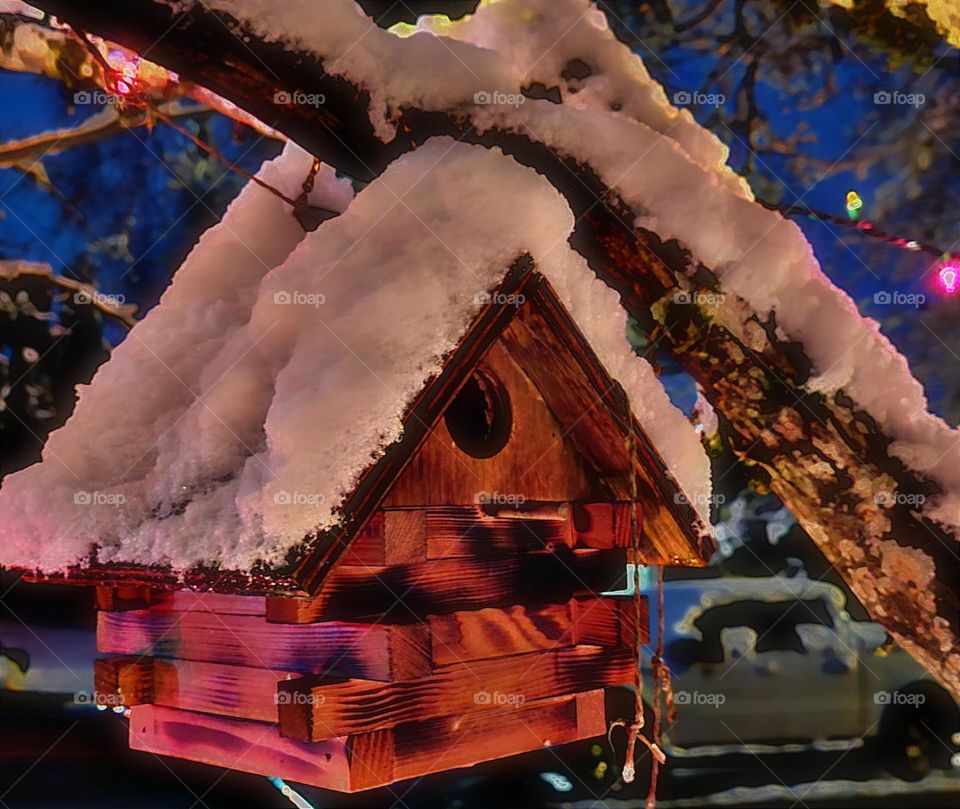 Christmas snow fallen on the roof of wooden bird house