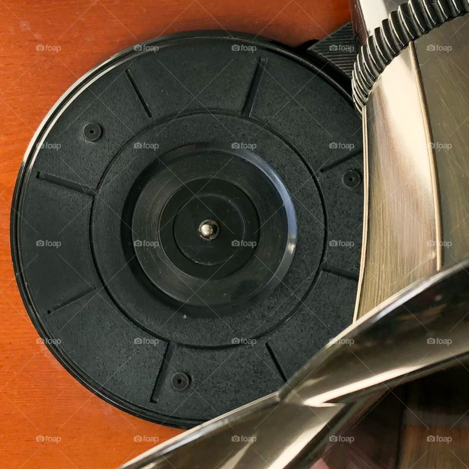 A retro gramophone seen from the top with the view of the speaker and turntable and a wooden base. 
