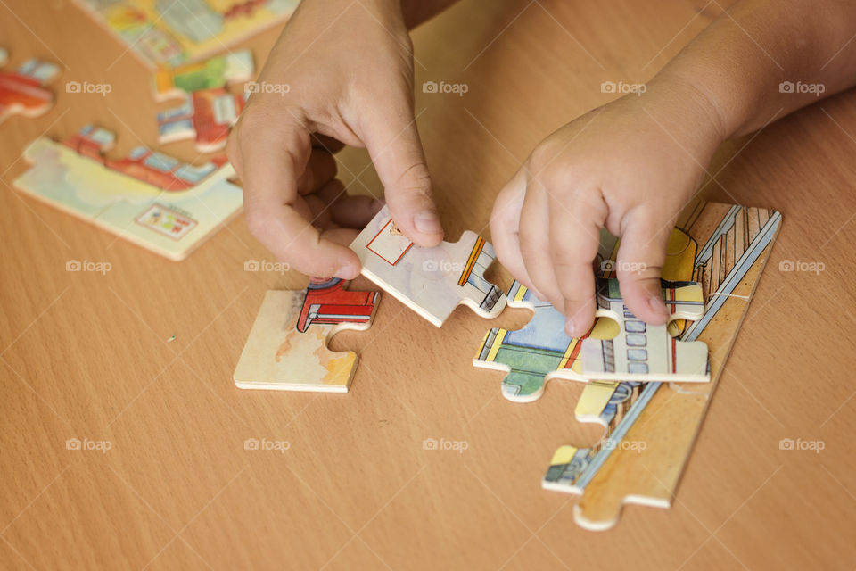 Two child playing jigsaw puzzle