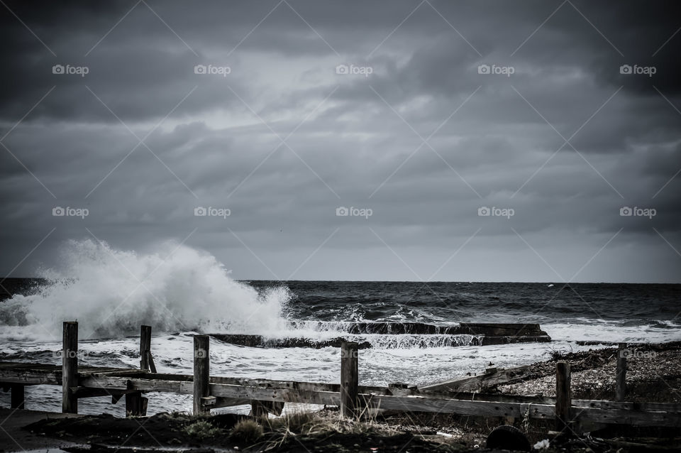Waves breaking over the harbour wall