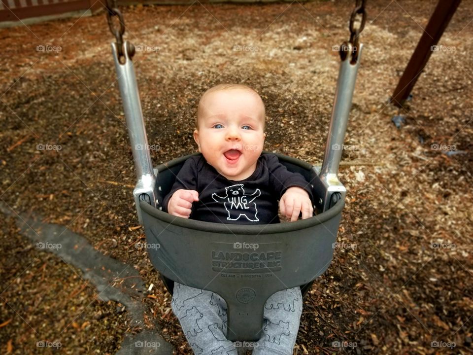 Cute little baby on playground swing