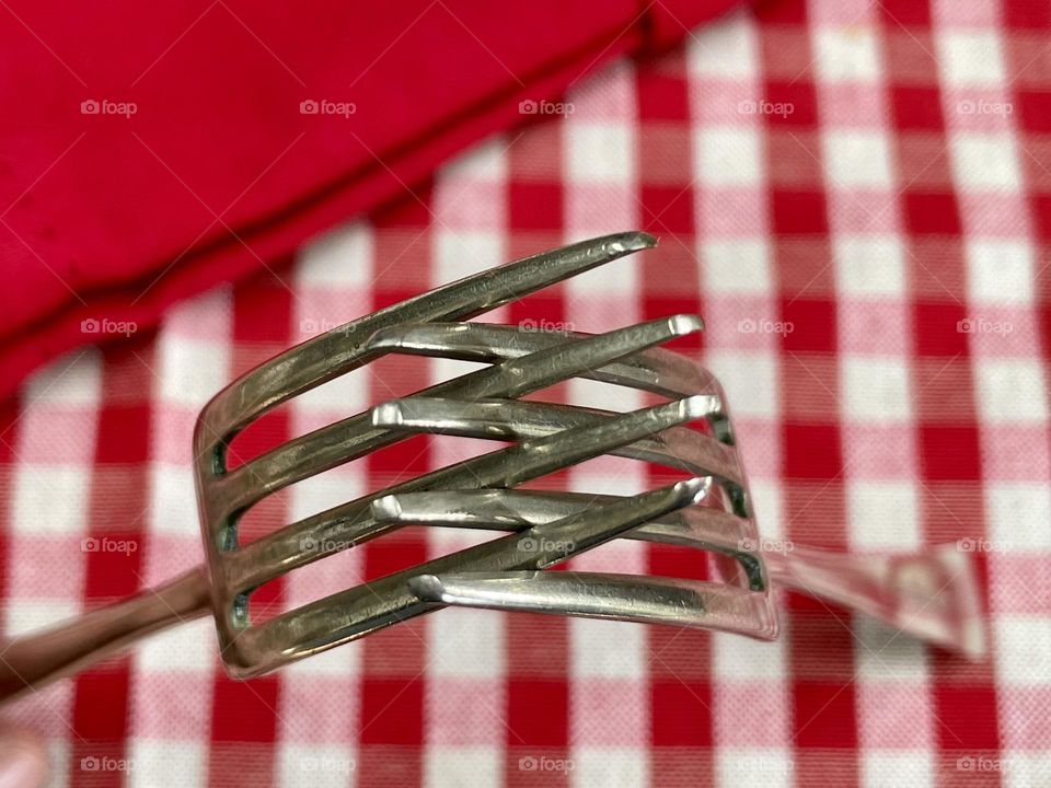 Interlinked forks on a red gingham tablecloth