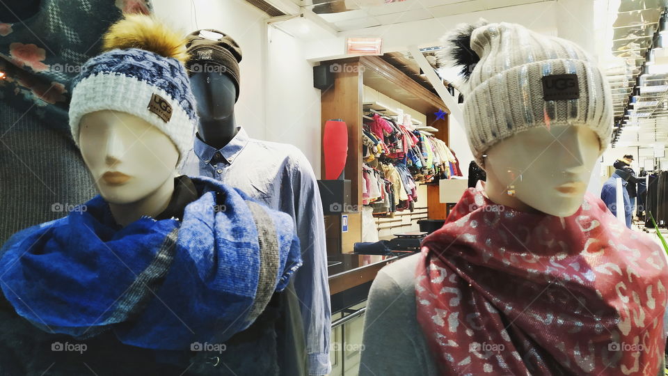 two mannequins behind the storefront