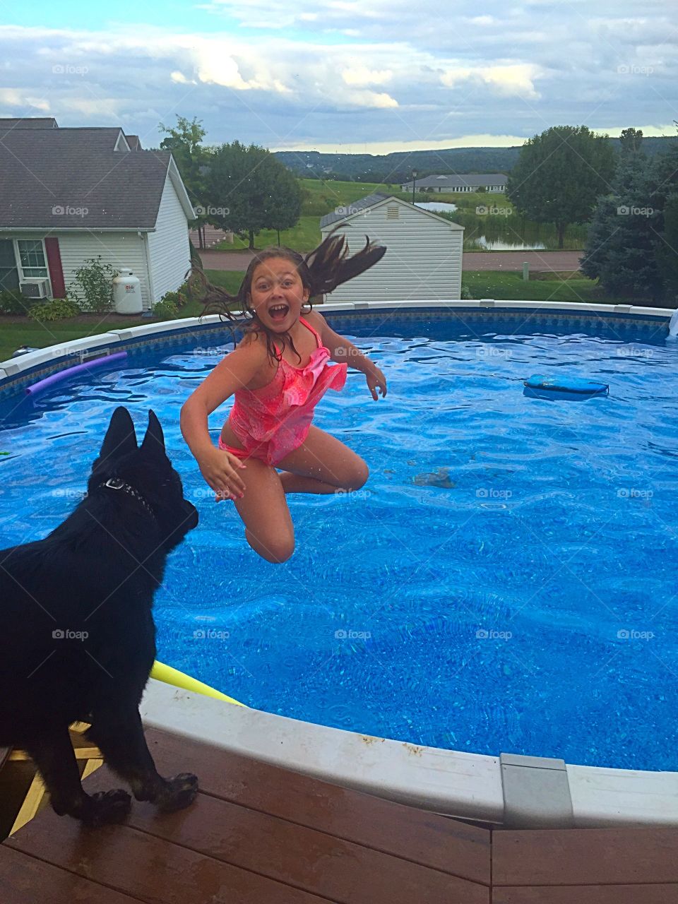 Girl with dog at pool side