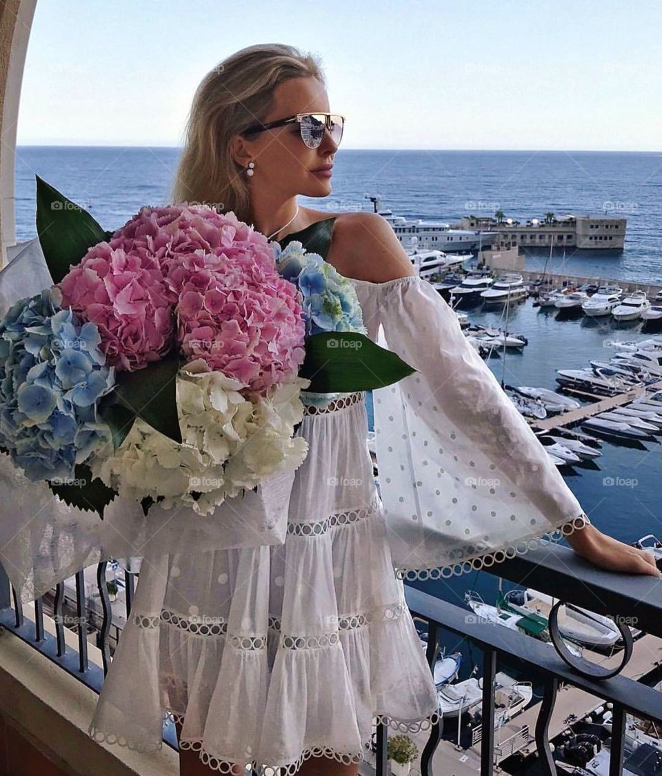 Beautiful girl posing on terrace with a bouquet, Montecarlo, Monaco