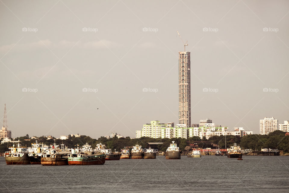Kolkata, India - May 13, 2018: Beautiful panorama of Kolkata city on the river Hooghly in a sunny day. Fishing trallers are floating on the river.