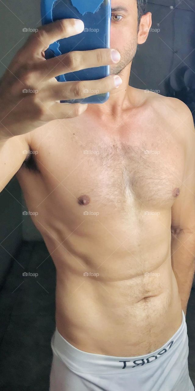 Man in the gym strong, defined. Fitness male body.