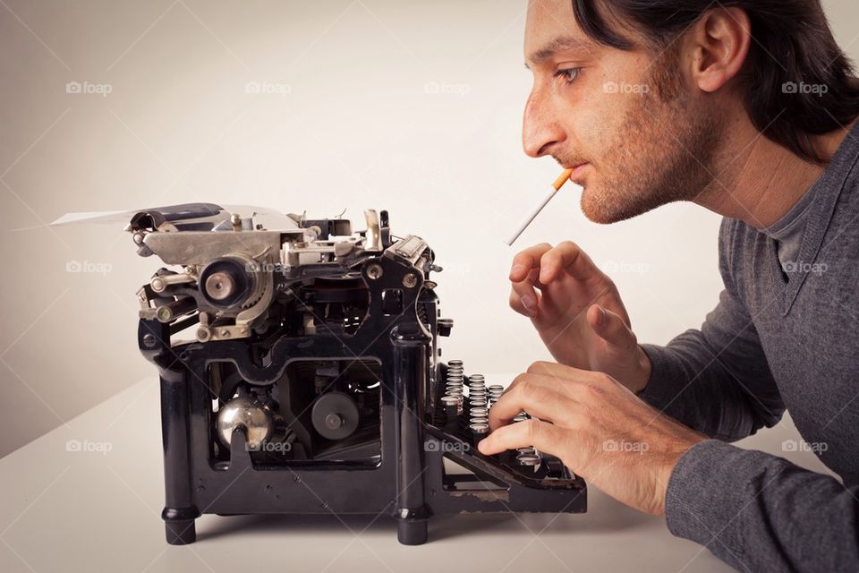 man who smokes and writes with a typewriter