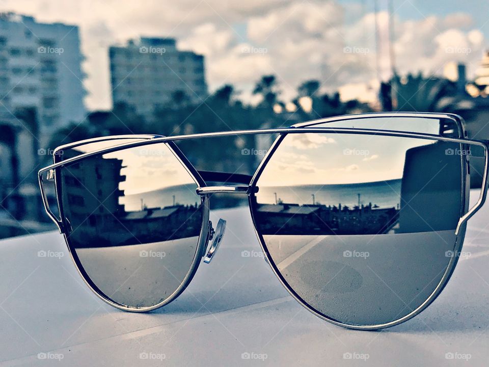 Sonnenbrille reflektiert den Urlaubsstrand und das Meer.