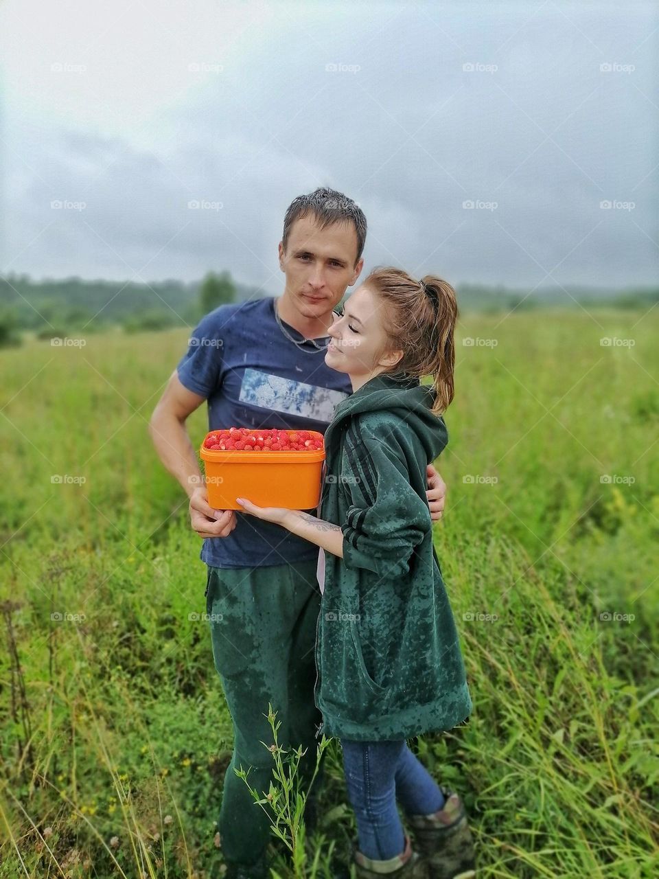 happy family couple hugging in the field. happiness together.