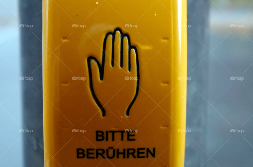 Close-up of yellow traffic light button in Berlin, Germany.