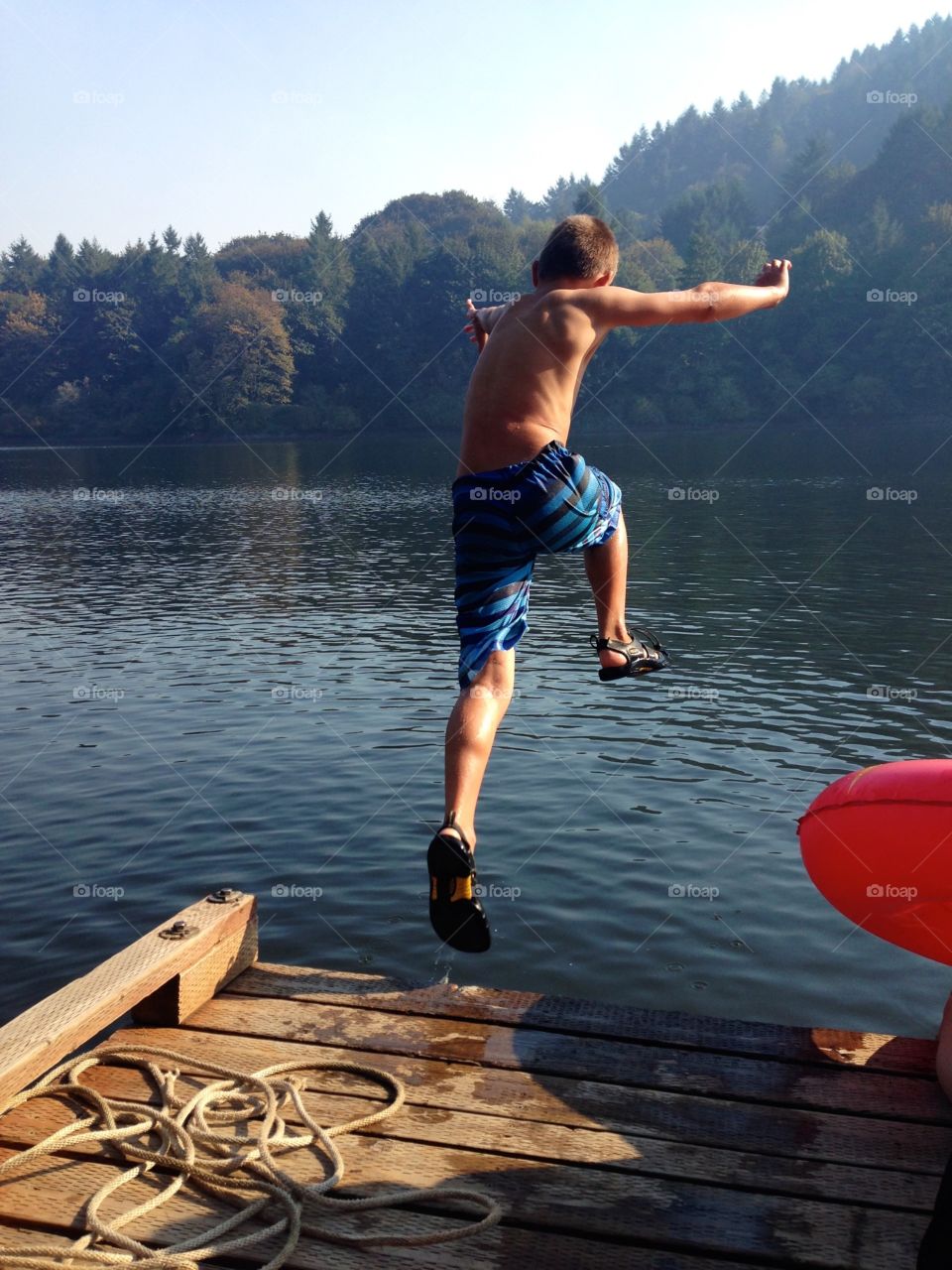 Jump. Young boy jumping in lake