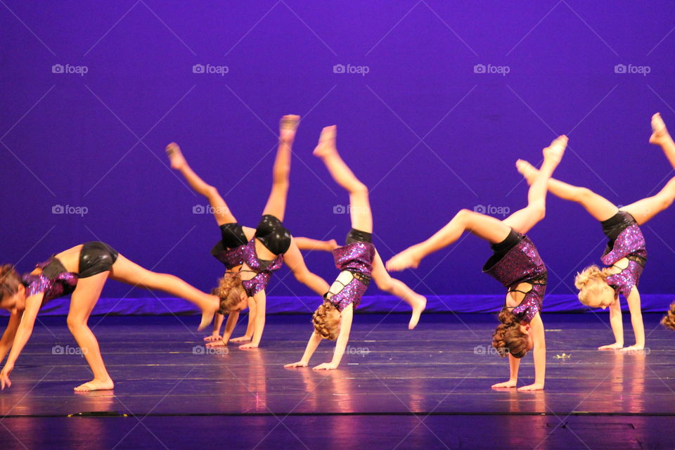 Take the stage. Dancers doing back flips at Dance recital