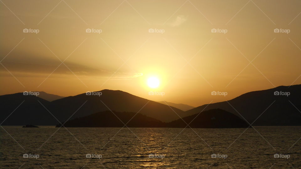Sunset over mountain at sea