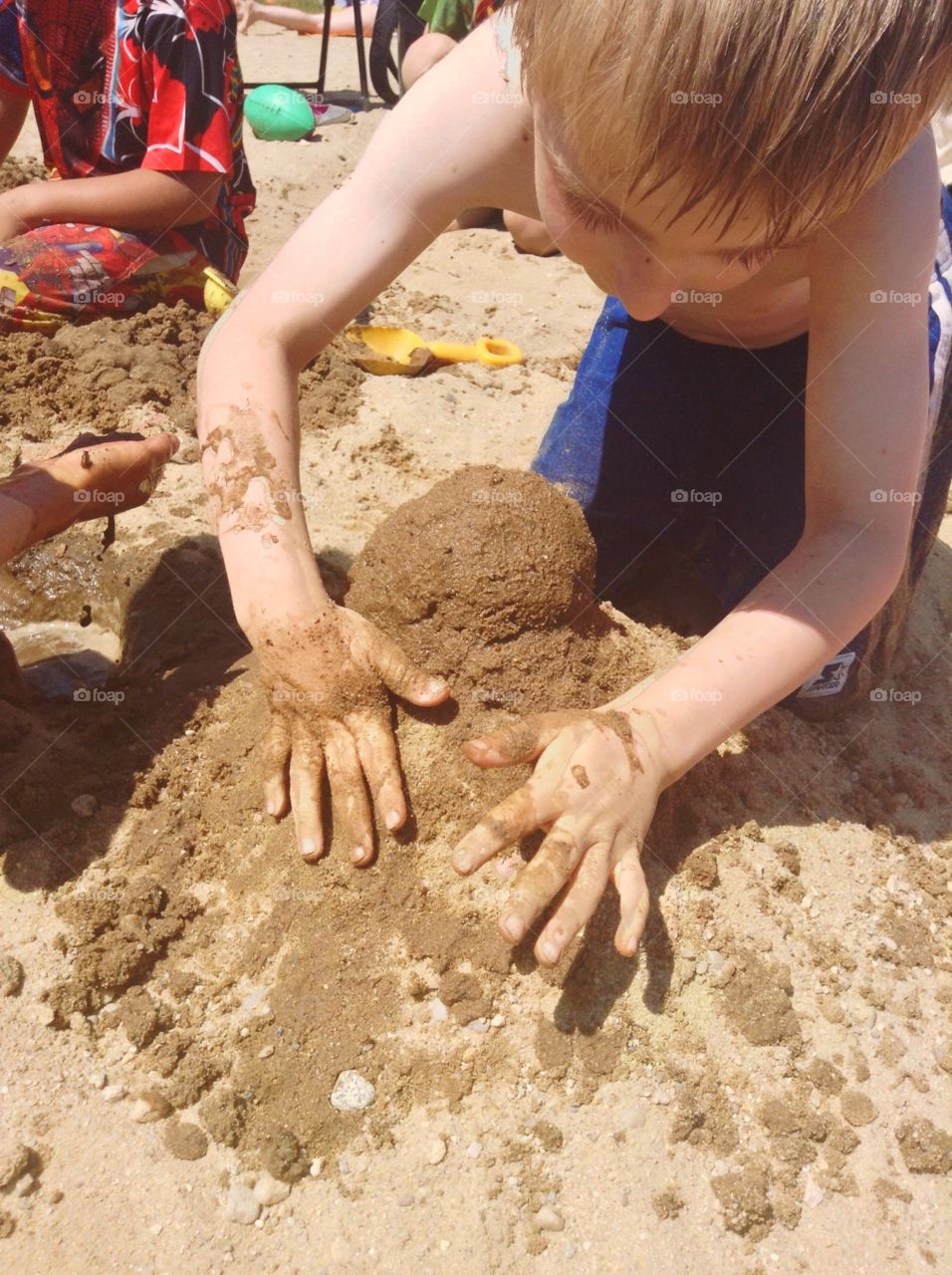Making a sandcastle. Kids building a sandcastle 