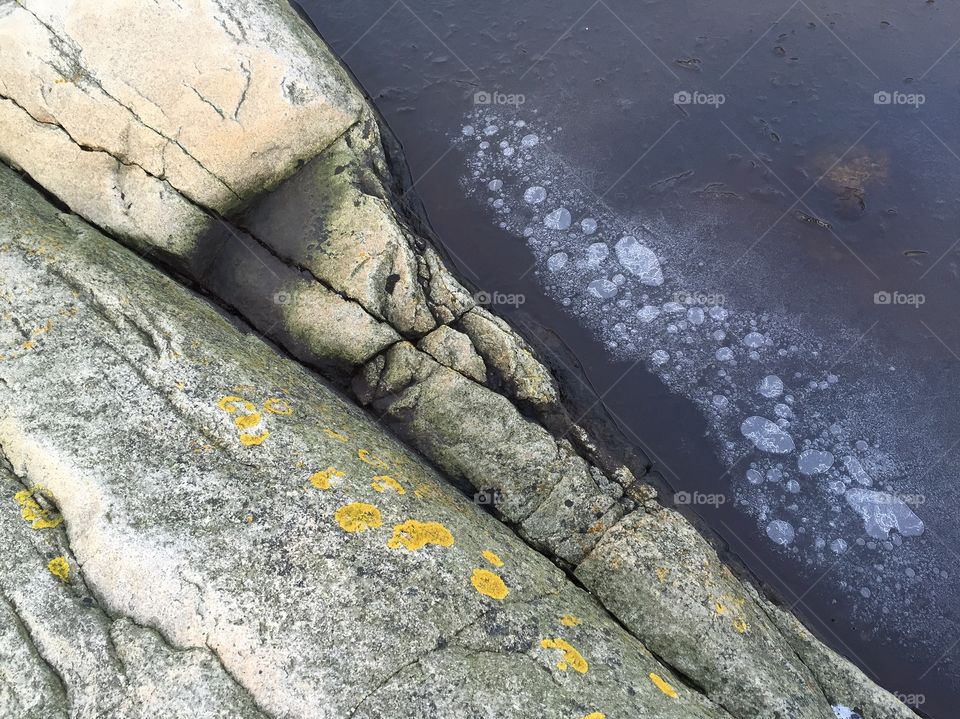 High angle view of rock and frozen bubbles