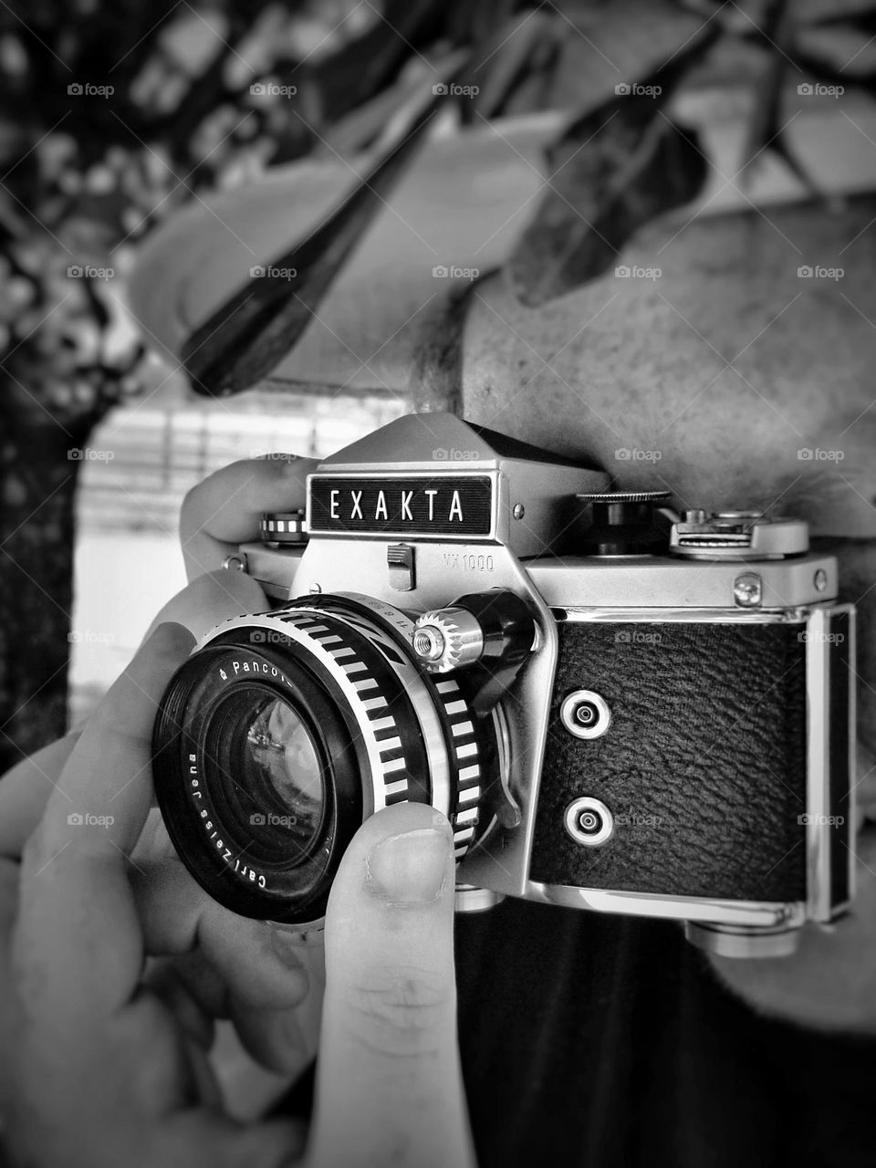 A black & white photo of a Man taking a photo with a vintage Exakta camera