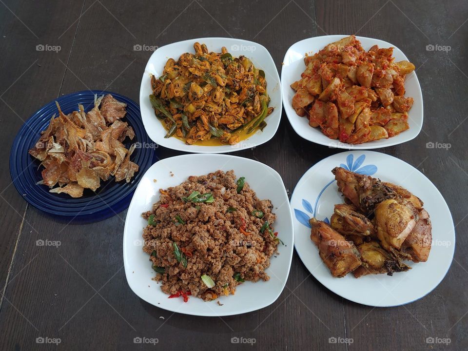 Indonesia traditional dishes set. Plated on 5 plate. which are : Ikan Asin Goreng, Tumis Kerang Hijau, Oseng Oncom, Balado Jengkol and Ayam Goreng.