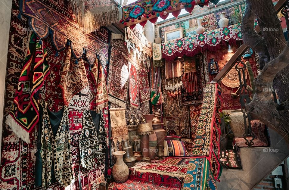 The stairwell is decorated with carpets and antiques.