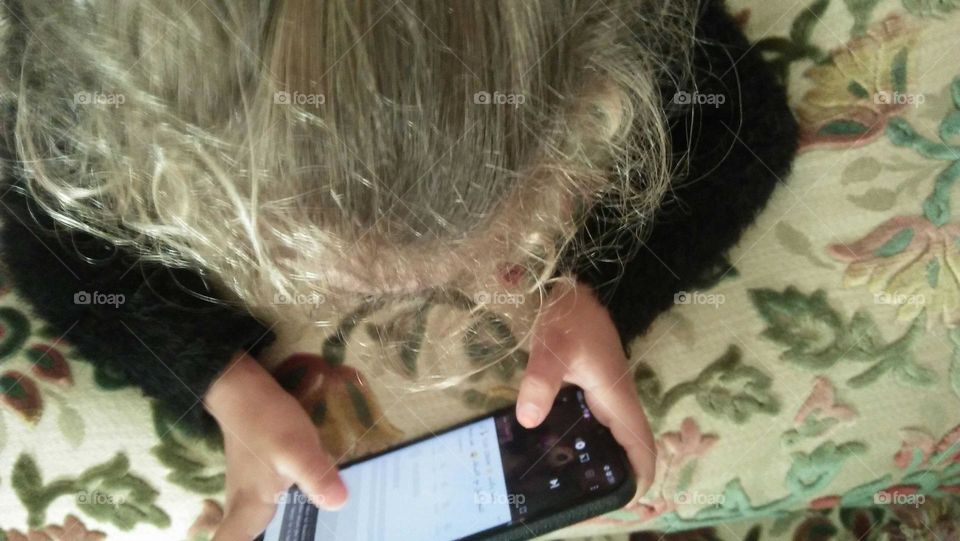 Beautiful young girl playing on its phone