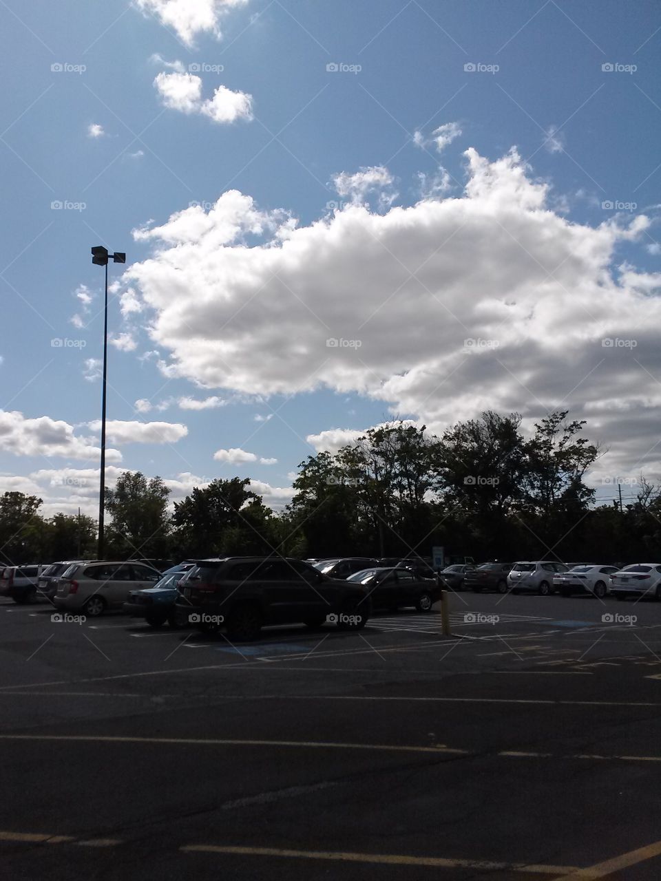 Fluffy clouds over parking lot