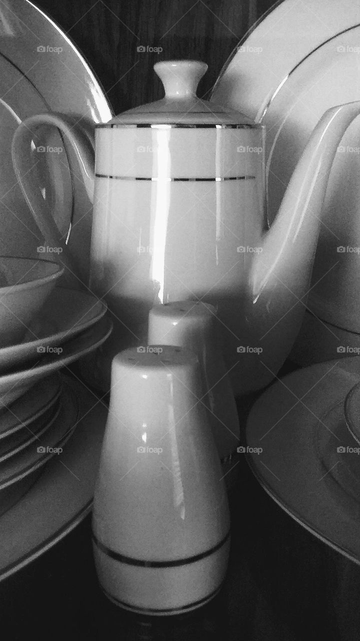 black and white photograph of dishes inside a cabinet