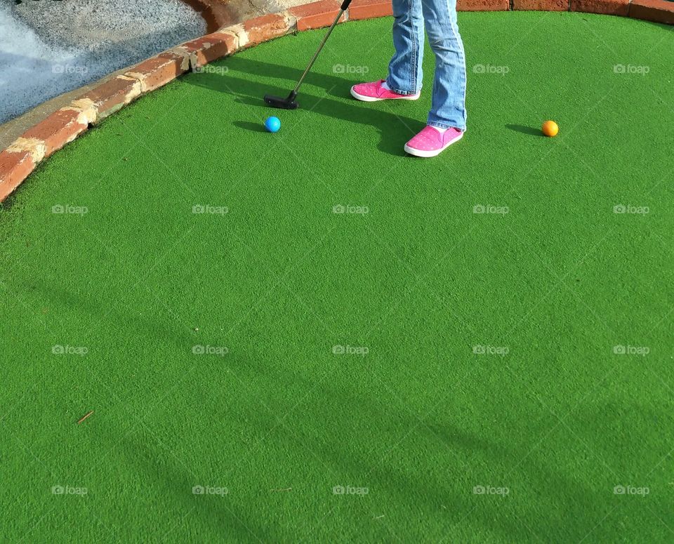 Girl playing mini golf