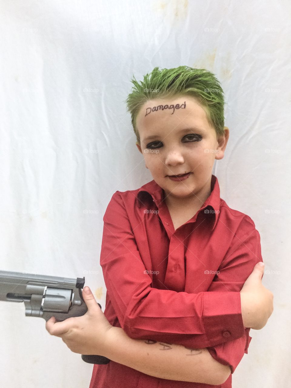 A joker boy with gun against white background
