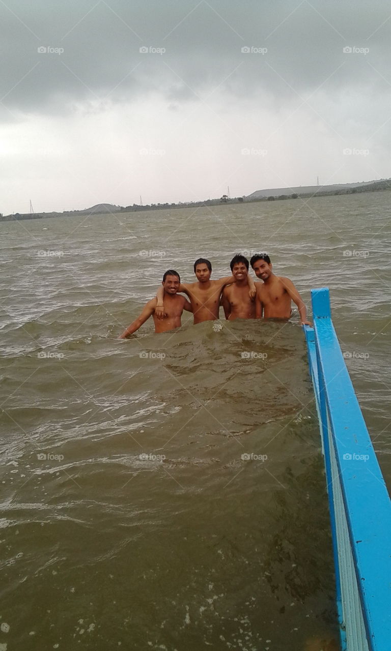 Group of shirtless male friends in sea